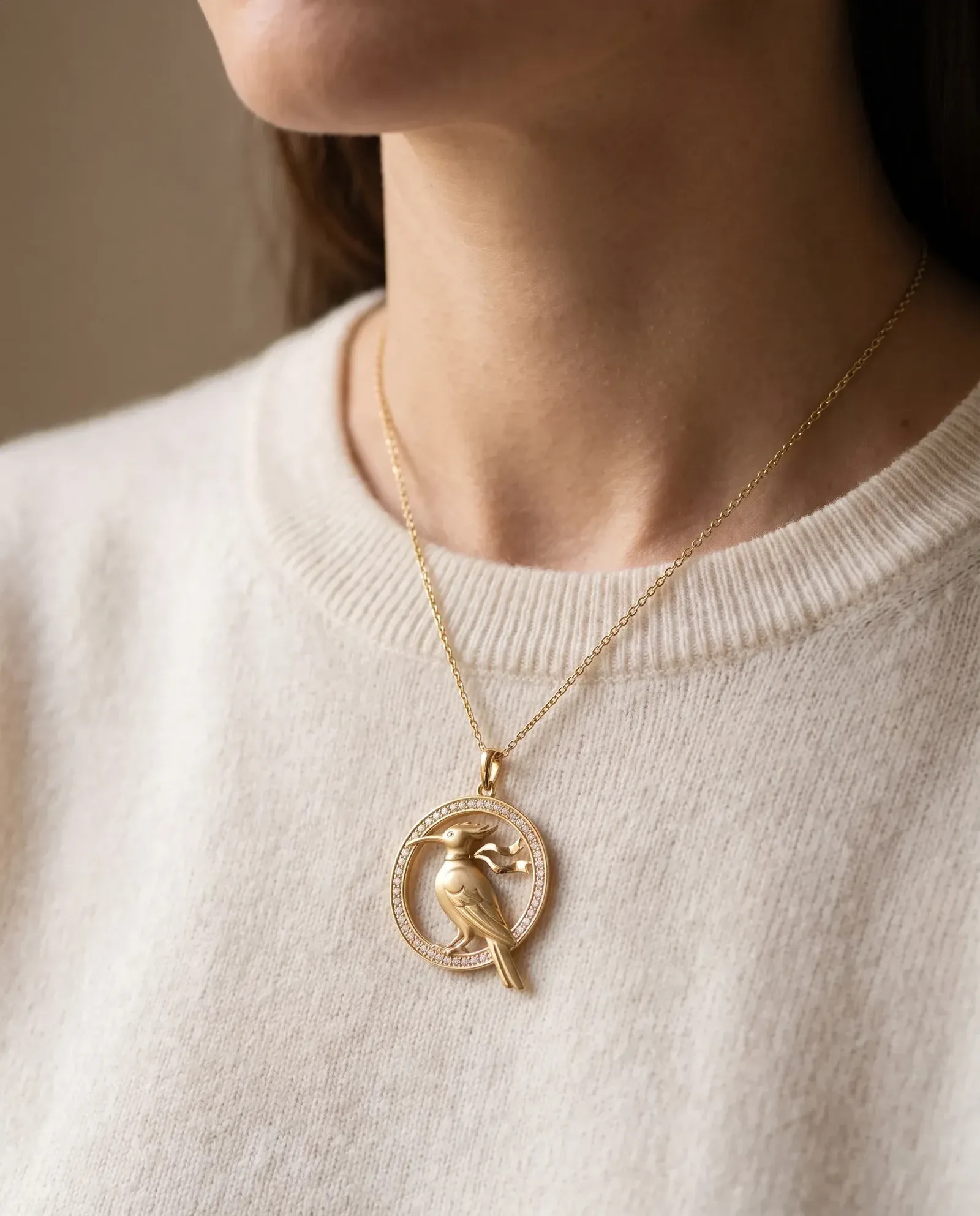 Design visualisation of the Hodhod Roundel Pendant worn at the throat: a pierced gold roundel on a fine chain, faceless, for scale.