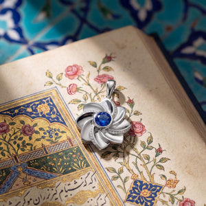 Gol-e Behesht pendant close-up showing eight-petal design and sapphire